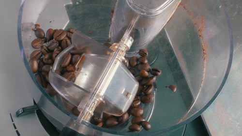 Pouring Coffee Beans into Grinder for Grinding