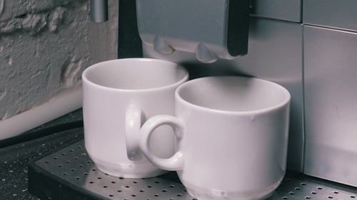 Coffee Machine Dispensing Coffee into Two Mugs