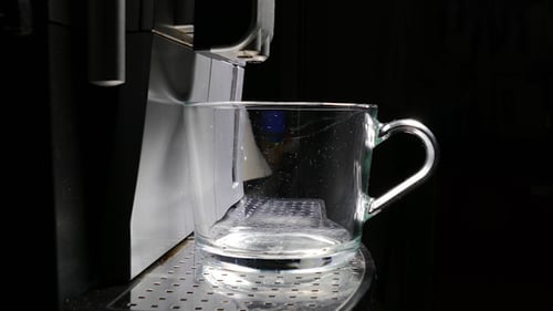 Espresso Pouring Into Clear Glass Mug Close Up