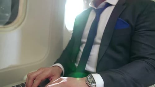 Businessman Working on Laptop During Flight