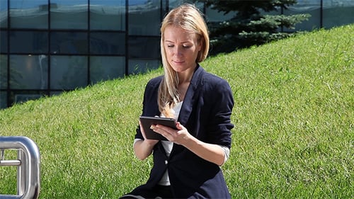 Woman Using Tablet Outdoors on Sunny Day
