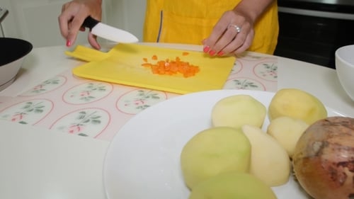 Woman Chopping Carrot in Kitchen for Cooking