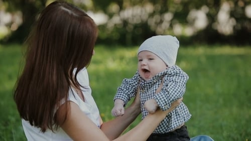 Happy Baby Boy Playing With Mother In The Park
