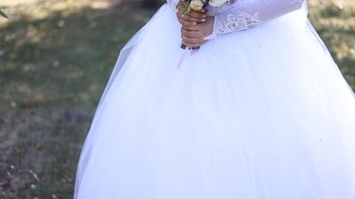 Elegant Bride Holding Bouquet in Beautiful Park