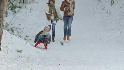 Pais correndo atrás do filho no trenó