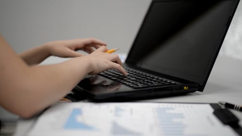 Tippen auf der Tastatur und Papierarbeit