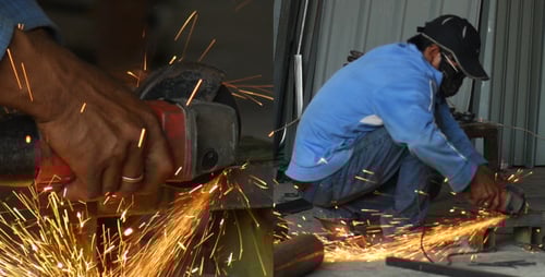 Worker Grinding Metal Sparks in Workshop