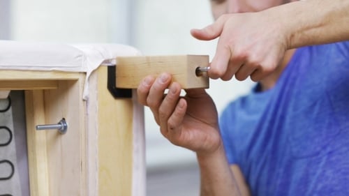 Man Assembling Leg To Sofa