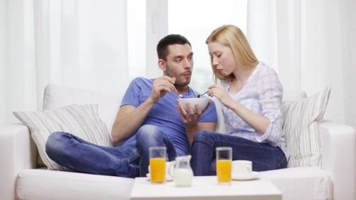 Couple Eating Together and Sharing From Bowl at Home