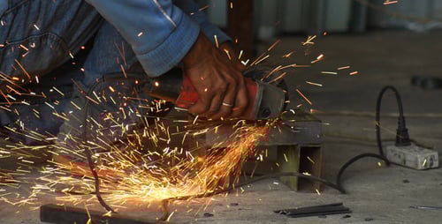 Man Grinding Metal Sends Sparks Flying