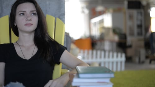 Young Woman Sitting in a Yellow Chair