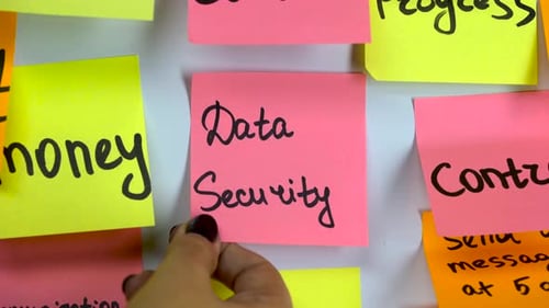 Hand Glues a Sticker with an Inscription Data Security on a Board