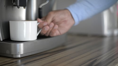 Taking Full Cup of Coffee from Coffee Maker