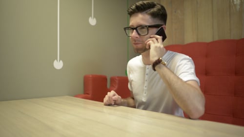 Young Adult Man Talking on Smartphone Indoors