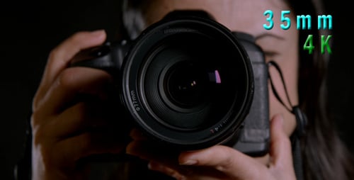 Woman Holds Camera Lens in Close Up Shot