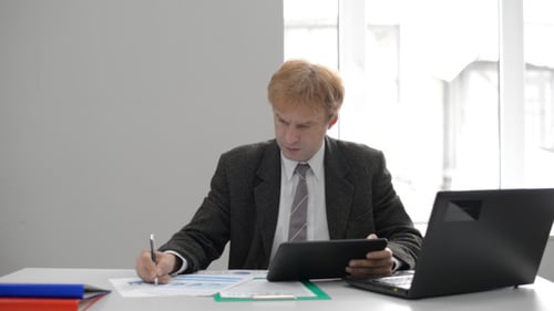 Man Reviews Business Data at Desk