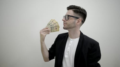 Young Man Cooling Off With Money