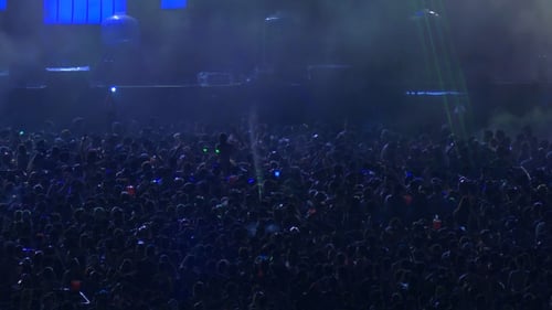 Huge Crowd at Concert with Backlit Stage