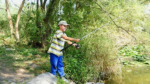 Boy Fishing With Spinning On The River