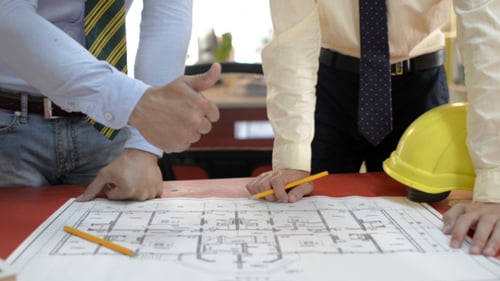 Architects Reviewing Blueprint on Tabletop