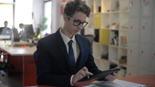 Young Adult Uses Tablet in Office Setting