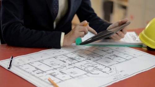 Engineers Using Tablet, Blueprint in Background
