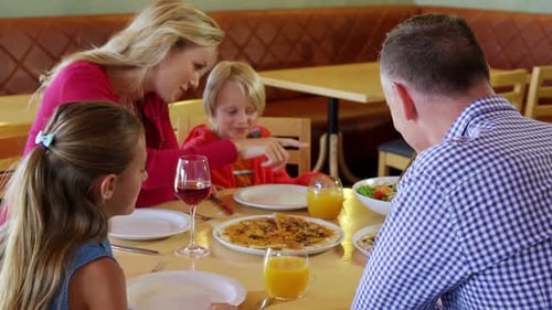 Family Enjoying Pizza Meal in Restaurant