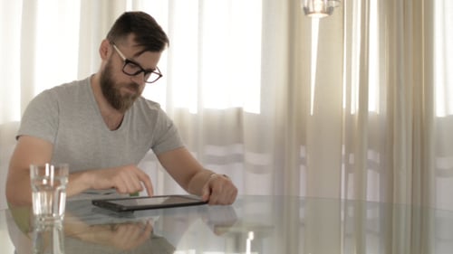 Man Using Tablet at Home in Bright Daylight