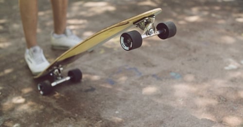 Skateboard Leaning Against Someone's Feet Ready to Ride