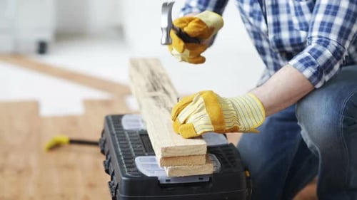 Close Up Of Man Hammering Nail To Wooden Board 1