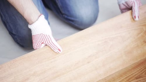 Close Up Of Man Installing Wood Flooring 10