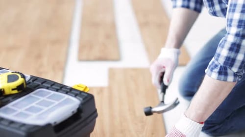 Close Up Of Man Installing Wood Flooring 3