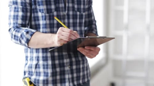 Close Up Of Man Looking And Writing To Clipboard 1