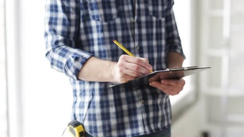 Close Up Of Man Looking And Writing To Clipboard 2