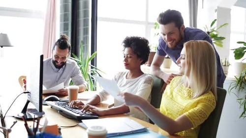 Equipe criativa feliz com computadores no escritório 10