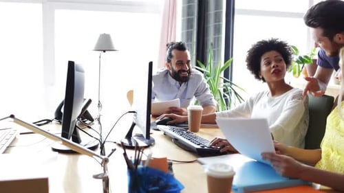 Equipe criativa feliz com computadores no escritório 11
