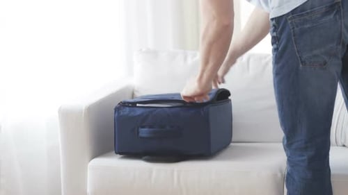 Close Up Of Man Packing Clothes Into Travel Bag 1