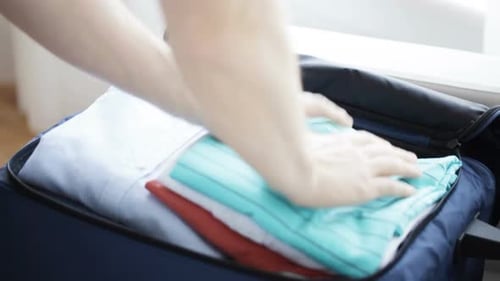 Close Up Of Man Packing Clothes Into Travel Bag 3