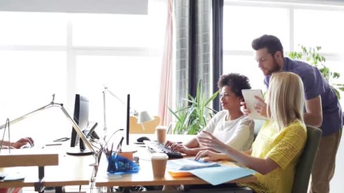 Equipe criativa feliz com computadores no escritório 4