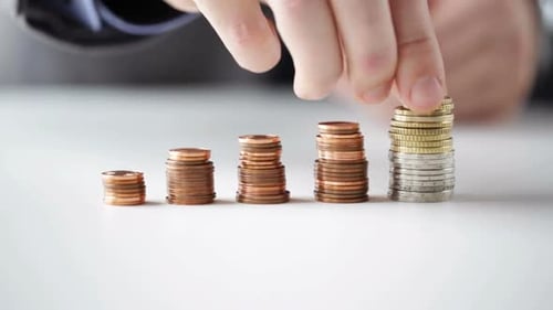 Close Up Of Businessman Putting Coins Into Columns 5