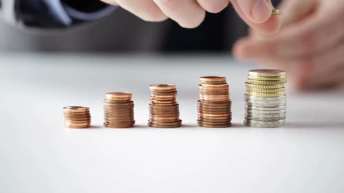 Close Up Of Businessman Putting Coins Into Columns 6