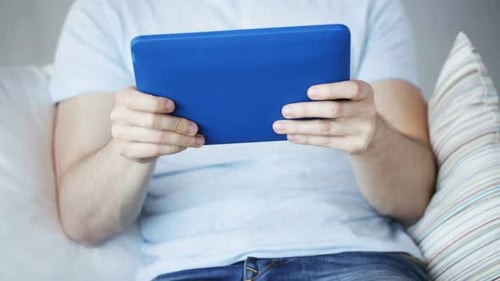 Nahaufnahme eines Mannes beim Spielen auf Tablet-PC zu Hause 4