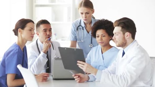 Group Of Doctors With Clipboard Talking At Clinic 1