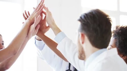 Group Of Happy Doctors Making High Five At Clinic 3