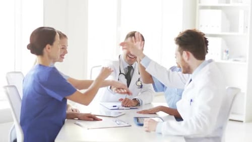 Group Of Happy Doctors With Hands On Top At Clinic 1