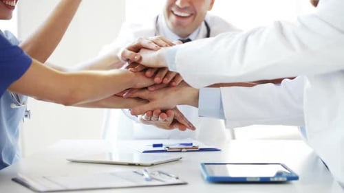 Group Of Happy Doctors With Hands On Top At Clinic 3
