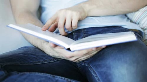 Nahaufnahme eines Mannes, der zu Hause ein Buch liest 4