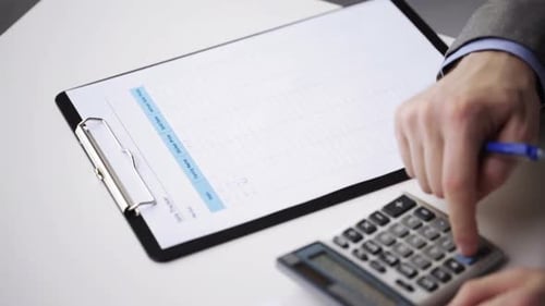 Nahaufnahme eines Geschäftsmannes mit Papieren und Taschenrechner 3