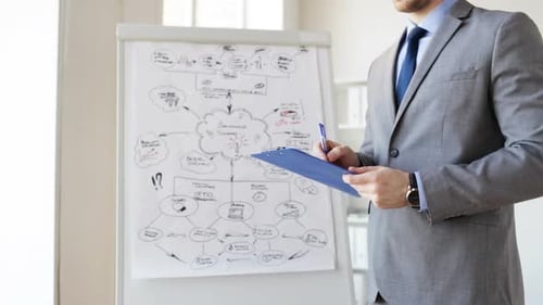 Close Up Of Man With Business Scheme And Clipboard 2