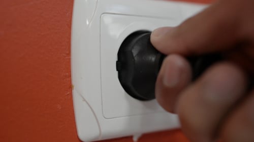 Hand Plugging European Electrical Plug Into Outlet